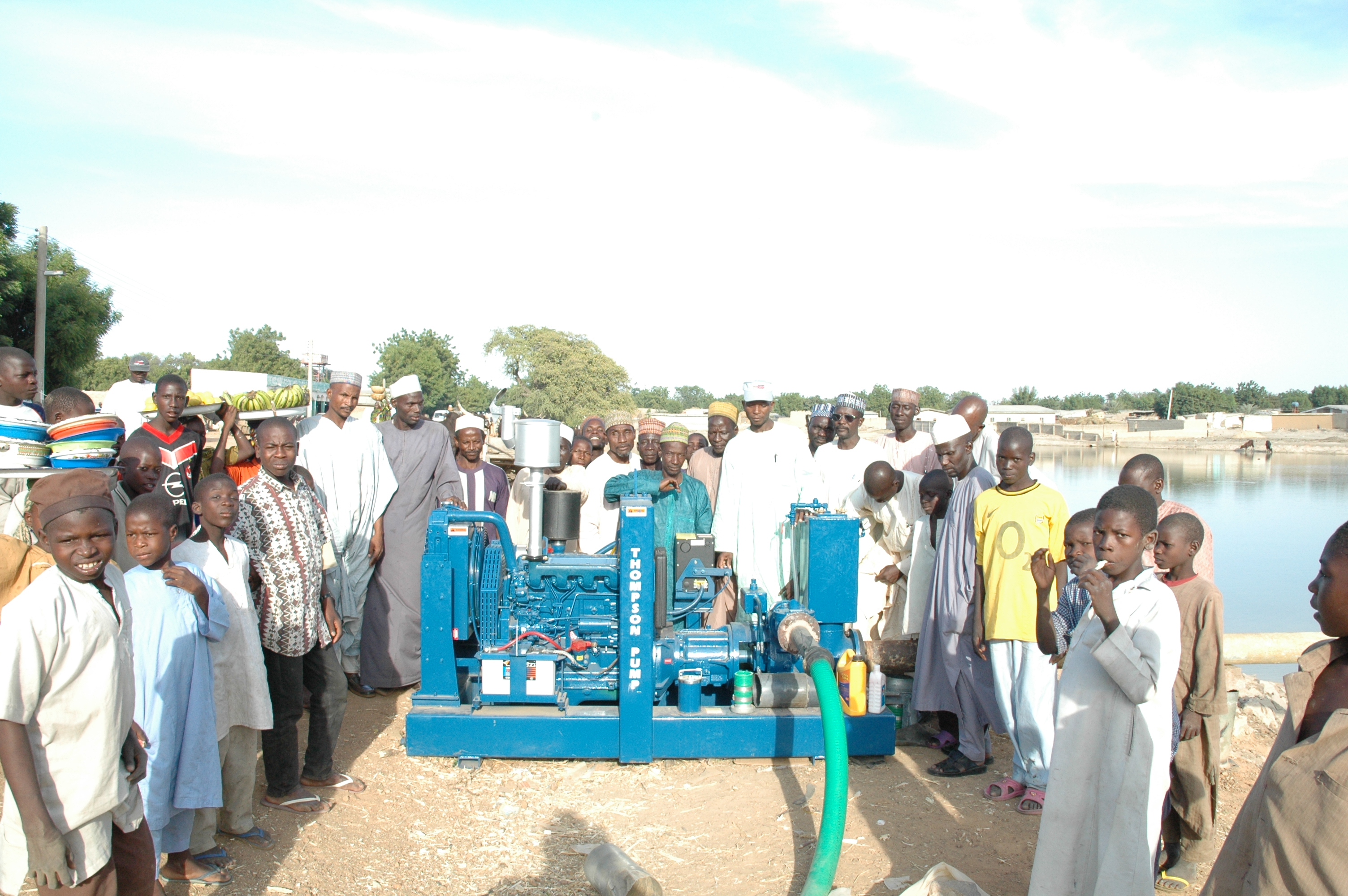Residents gather around one of 30 pumps that were purchased for an agricultural improvement project to bring water to a remote village in Africa.