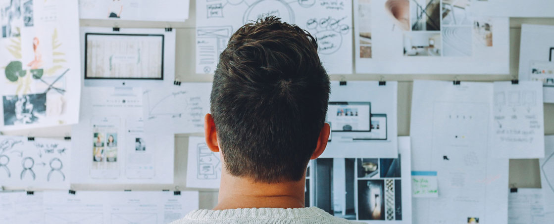 Man staring at wall with pictures