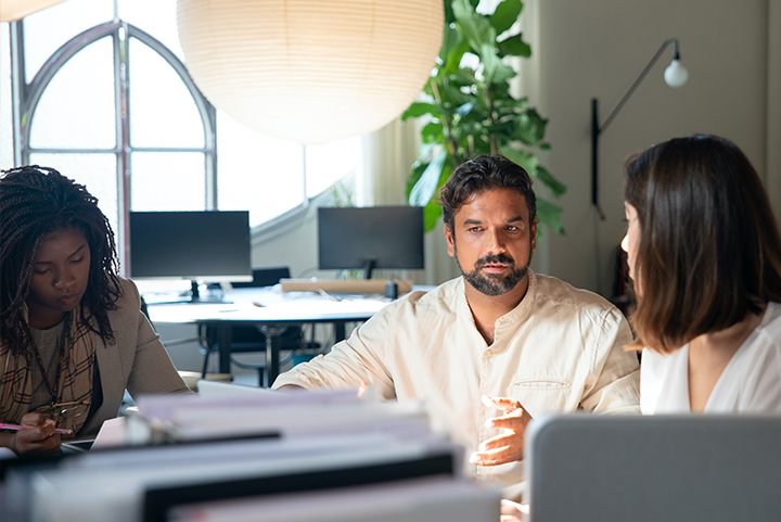 Coworkers talking at a desk