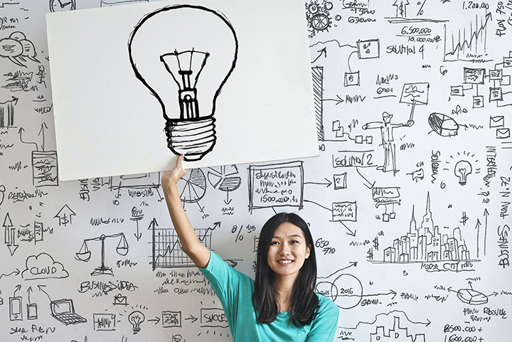 Woman holding a lightbulb sign for a business idea